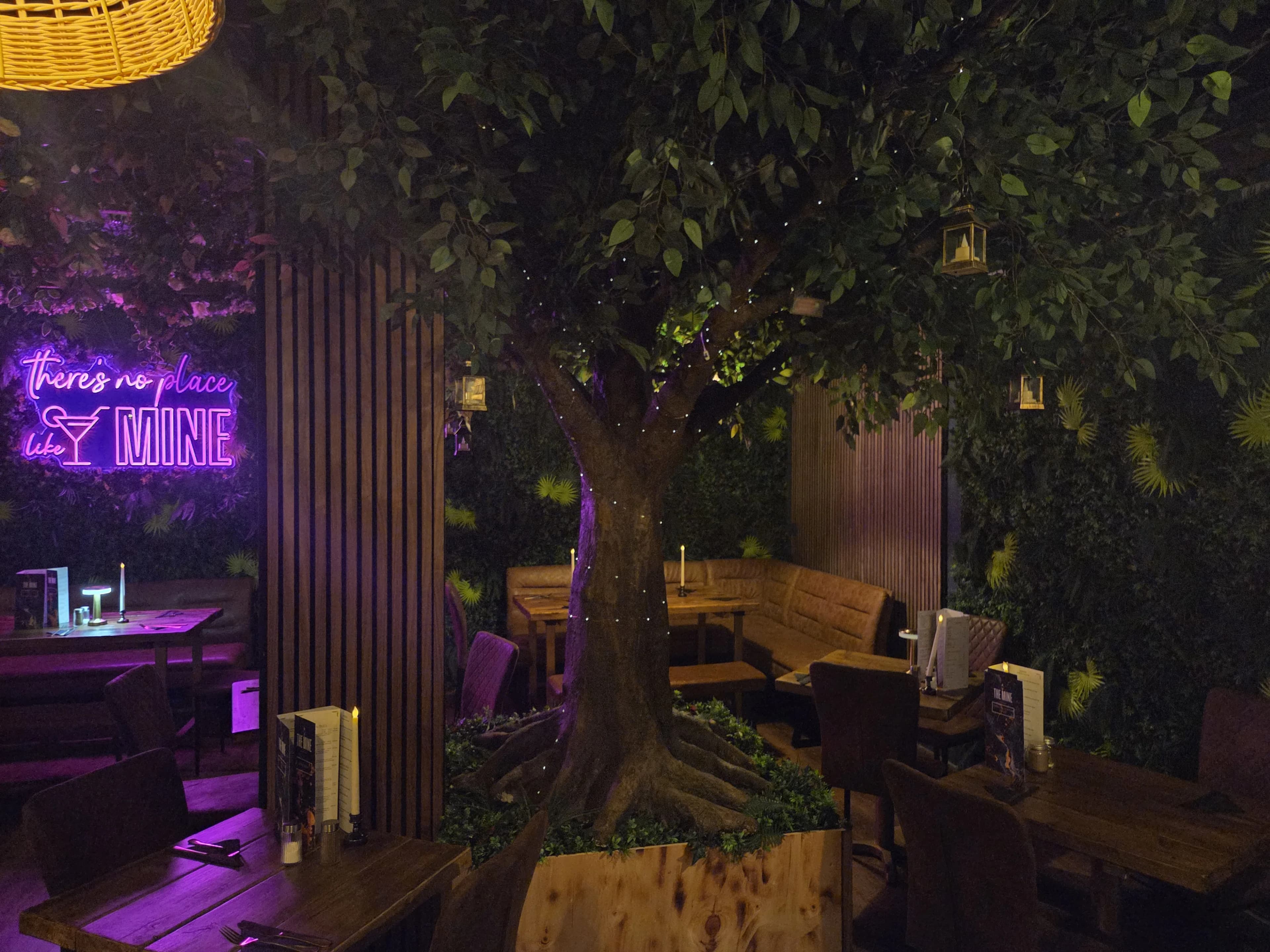 The Mine restaurant interior featuring authentic coal mine theming with industrial elements and atmospheric neon lighting in Neath